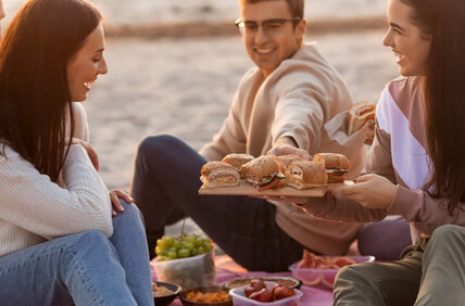 Eine Gruppe von Freunden macht ein Picknick am Strand.